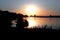 Romantic silhouette of the girl by the river playing guitar