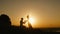 Romantic Silhouette of Man Getting Down on his Knee and Proposing to Woman on high hill - Couple Gets Engaged at Sunset