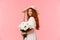 Romantic, silly and tender feminine redhead woman in cute hat, dress, holding bouquet white flowers, turn camera and