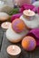 Romantic spa with bath bomb, tulips, candles and pebbles on wooden background.