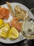 Romantic still life with a glass of white wine on the table, a plate with salted and smoked red fish, slices of lemon