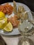 Romantic still life with a glass of white wine on the table, a plate with salted and smoked red fish, slices of lemon