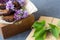 Romantic still life with lilac flowers and brownie, wet cake. Dessert for served for tea or coffee break in wooden box. Snack on a