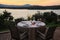 Romantic summer evening in the restaurant - table served for four persons with a sunset view at the lake Marathon, Greece.