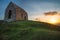 Romantic sunset on Cornish coast with lonelly chapel on cliff.