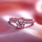 Romantic symbol diamond engagement ring on pink silk fabric Love