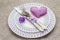 Romantic table setting on light stone concrete background. Valentine`s day or Wedding card template. Lilac felt heart, lavender,