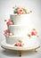 Romantic three tiered wedding cake, with pastel pink rose flowers, on a gold stand. Hand painted Rococo style with intricate icing