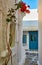 Romantic traditional alleyway of Greek island towns. Whitewashed walls, blue doors and sky, pink bougainvillea