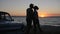 Romantic Trip of Lovers on seafront in sunset, summer rest of young couple on shore sea, silhouette of pair