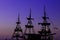 Romantic vacation cruise ship wooden medieval mast dark silhouette and gas lamps illumination on blue and purple sunset evening