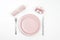 Romantic or Valentines day dinner background. Festive table setting with pink tableware, gift and napkin. Valentine`s card