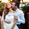 Romantic valentynes couple of newlyweds hugging at kissing at sunset near a wooden house