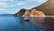 Romantic view of beautiful boat on the sea and majestic rocks in sunlight.