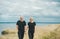 Romantic view of couple in black clothes when they walking on the edge of the rocky coast of the Baltic sea