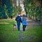 A romantic walk between two lovers with their dogs in a tree-lined street.