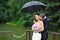 Romantic wedding couple kissing in a rainy day