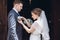 Romantic wedding moment, beautiful blonde bride putting on boutonniere on handsome groom near church entrance, newlywed couple