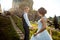 Romantic wedding portrait of the beautiful newlywed holding hands. The groom is leading the charming bride along the