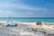 Romantic white picnic tent on white sand beach with crystal clear water and blue sky at background.