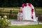 Romantic white wedding aisle archway with rose petals, flowers a