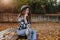 Romantic white woman with long brown hair looking away with dreamy smile, posing in sunny autumn day. Elegant curly