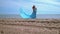 Romantic woman in blue dress on beach. Pregnant woman holding belly
