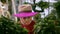 Romantic woman in hat looking through green plant in orangery. Portrait beautiful woman in hat posing in garden with