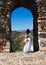 Romantic woman near arch of medieval town