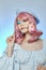 Romantic woman with pink hair in a blue beret on her head, a French woman with a rose in her hands. Blue makeup on the eyes