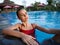 romantic woman in red swimsuit swim in transparent pool water travel model relax