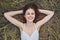 romantic woman in a white dress lies in a haystack in nature and holds her hands behind her head