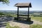 Romantic wooden tourists shelter with seats and table on viewpoint, beautiful landscape