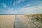 Romantic wooden trail or boardwalk on a beach leads to a calm Baltic Sea conveying realisation concept. Success path illustration