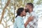 Romantic young African man kissing his girlfriend`s forehead outdoors