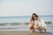 Romantic young couple draw heart shapes in the sand while on honeymoon. summer beach love concept.