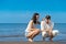 Romantic young couple draw shapes in the sand while on honeymoon.