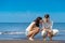 Romantic young couple draw shapes in the sand while on honeymoon.