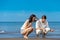 Romantic young couple draw shapes in the sand while on honeymoon.