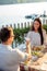 Romantic young couple making a toast, celebrating their anniversary or birthday in a restaurant by water