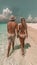 Romantic young couple strolling on white sand beach in a tropical paradise island destination