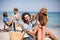 Romantic young couples sitting on deck chairs at beach