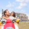 Rome couple on scooter by Colosseum, Italy