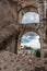 Rome, Italy - 23 June 2018: Ruins of the roman forum viewed through the gated arch of the passage at the entrance of the Roman