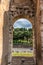 Rome, Italy - 23 June 2018: Ruins of the roman forum viewed through the gated arch of the passage at the entrance of the Roman