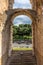 Rome, Italy - 23 June 2018: Ruins of the roman forum viewed through the gated arch of the passage at the entrance of the Roman