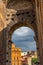 Rome, Italy - 23 June 2018: Ruins of the roman forum viewed through the gated arch of the passage at the entrance of the Roman