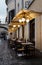 Rome, Italy - August 20, 2018: Typical old Roman narrow street. Lovely sidewalk cafÃ© with empty tables, umbrellas and lanterns.