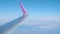 Rome, Italy - February 14, 2020: Wizzair plane wing in air against blue sky and white clouds. New route opening