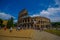 ROME, ITALY - JUNE 13, 2015: Roman coliseum view from outside, turists walking and visiting this iconic structure